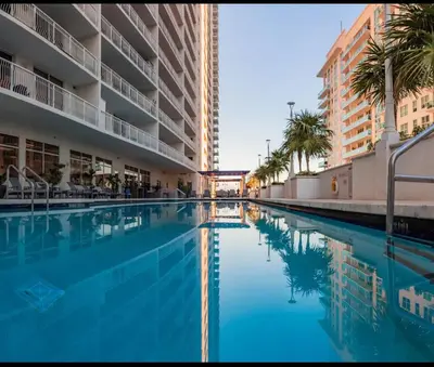 a large swimming pool with palm trees and buildings at Brickell 1 Bed 1 Bath Free Parking in Miami