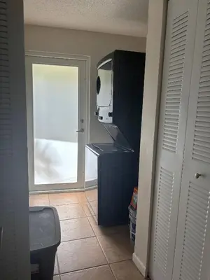 a kitchen with a tv and a door with a window at Palace at the Gables in Miami