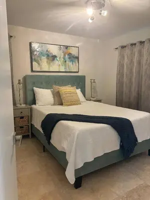a bedroom with a large bed with a green headboard at Palace at the Gables in Miami