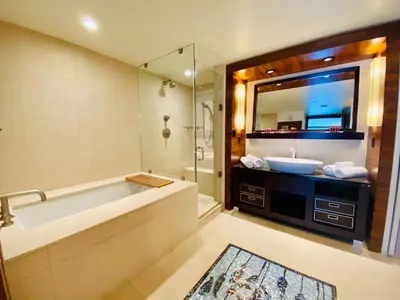 a bathroom with a tub and a sink and a mirror at Carillon Miami Beach Private Luxury Suites in Miami Beach