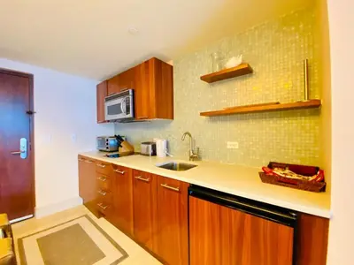 a kitchen with wooden cabinets and a sink at Carillon Miami Beach Private Luxury Suites in Miami Beach