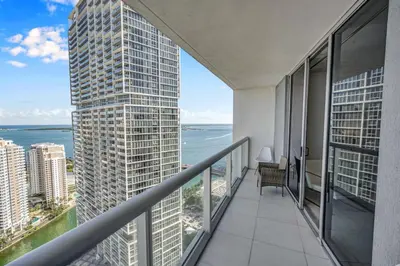 an apartment balcony with a view of the ocean at Sun, Style and Skyline Modern Icon Brickell 2BR in Miami