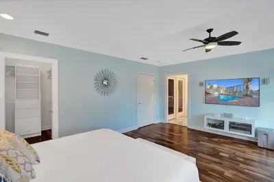 a bedroom with a bed and a ceiling fan at Massive waterfront home with pool in North Miami Beach
