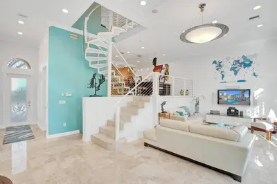 a living room with a staircase and a couch at Massive waterfront home with pool in North Miami Beach