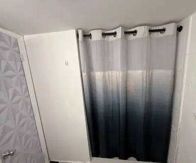 a bathroom with a shower curtain and a mirror at Walk to South Beach in Miami Beach
