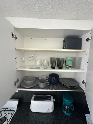 a kitchen shelf with dishes and a toaster at Walk to South Beach in Miami Beach