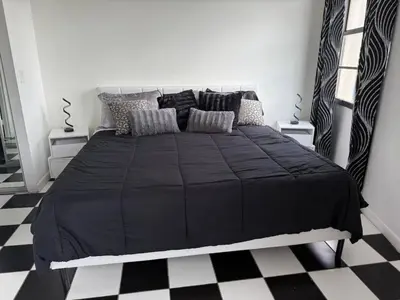 a bedroom with a black bed with black and white checkered floors at Walk to South Beach in Miami Beach
