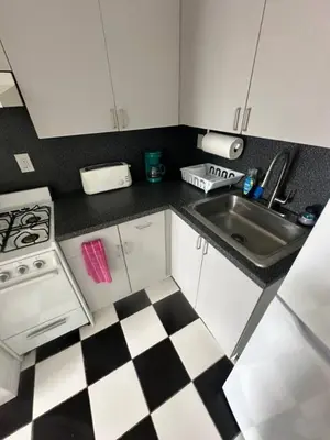 a kitchen with a black and white checkered floor at Walk to South Beach in Miami Beach