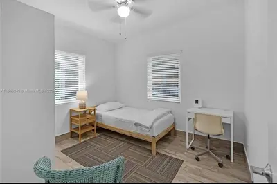 a bedroom with a bed and a desk and a chair at Avocado House A Coconut Grove Bungalow in Miami