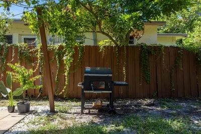 a backyard with a fence and a tv in the yard at 10 min to Las Olas and Beach WD 2 Bed in Fort Lauderdale