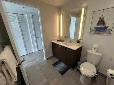 a bathroom with a toilet and a sink and a mirror at Luxury Downtown Miami Stay in Upscale Building in Miami