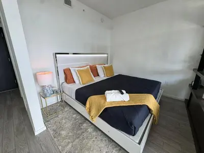 a bedroom with a bed with a yellow blanket on it at Luxury Downtown Miami Stay in Upscale Building in Miami