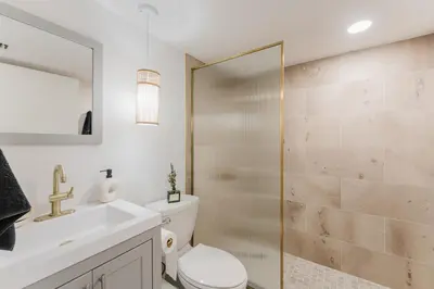 a bathroom with a shower and a toilet and a sink at Waterfront Villa with Beach, Game Room, Cinema and Spa in Pembroke Pines