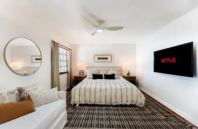 a bedroom with a bed and a tv on the wall at Waterfront Villa with Beach, Game Room, Cinema and Spa in Pembroke Pines