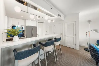 a kitchen with a bar with blue chairs at Ocean View Private Residence at Fontainebleau -3505 in Miami Beach