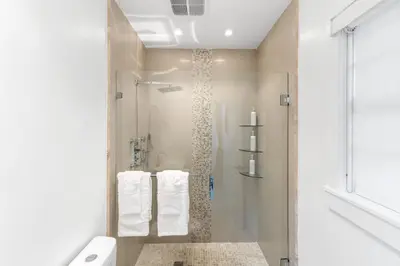 a bathroom with a shower with towels and a toilet at Stylish Bedroom Suite in Pembroke Pines