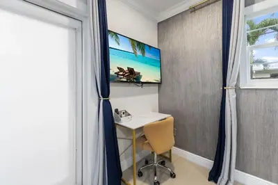 a desk in a room with a window and a television at Stylish Bedroom Suite in Pembroke Pines