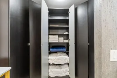 a walk in closet with black cabinets and towels at Stylish Bedroom Suite in Pembroke Pines