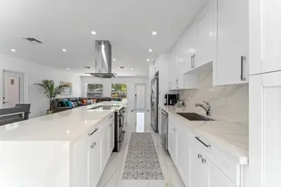a white kitchen with white cabinets and a sink at Family Splash Escape in Fort Lauderdale