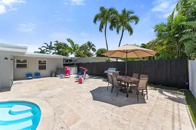 a patio with a table and chairs and an umbrella at Family Splash Escape in Fort Lauderdale
