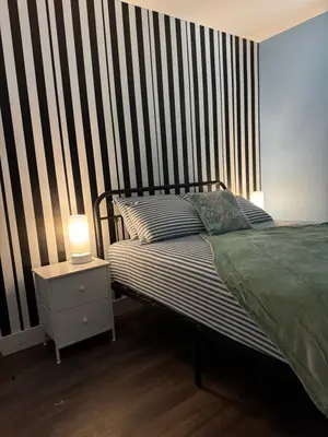 a bedroom with a bed and a striped wall at House FLL airport in Fort Lauderdale