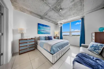a bedroom with a bed and a couch and a window at Midblock Midtown Miami High Floor 1B Suite W Spa Pool Gym in Miami