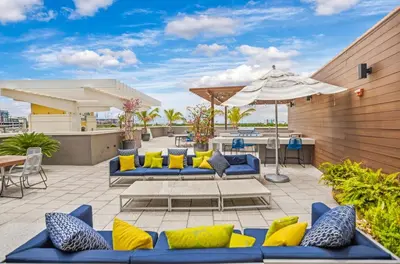 a patio with blue and yellow furniture and an umbrella at Midblock Midtown Miami High Floor 1B Suite W Spa Pool Gym in Miami