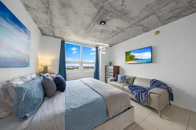 a bedroom with a large bed and a couch at Midblock Midtown Miami High Floor 1B Suite W Spa Pool Gym in Miami