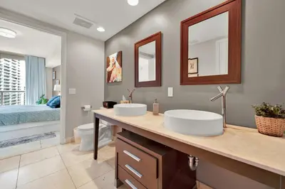 a bathroom with two sinks and a toilet and a bedroom at Luxurious 5-STAR condo at the ICON Brickell in Miami