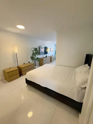a bedroom with a large bed and two night stands at SeaStays- South Beach Apartments in Miami Beach