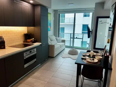 a kitchen with a table and a living room at The Art Studio Downtown in Miami