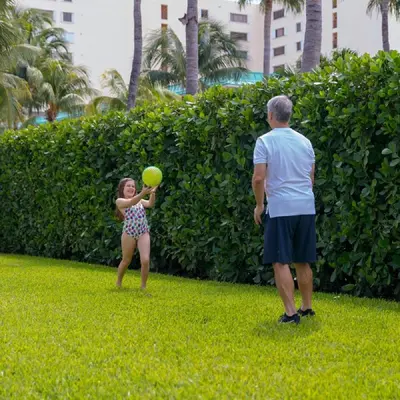 a man and a girl playing with a ball in the grass at Beach Haus Key Biscayne Contemporary Apartments in Miami