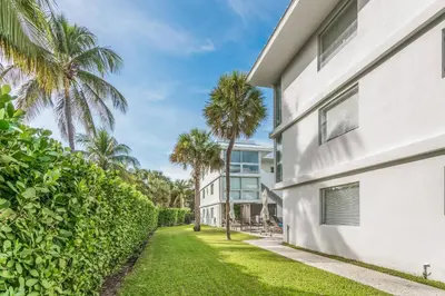 an exterior view of a white house with palm trees at Beach Haus Key Biscayne Contemporary Apartments in Miami
