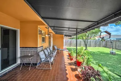 a patio with couches and chairs on a house at Lime Haus lime - Your Family Stay in Miami Awaits in Tamiami