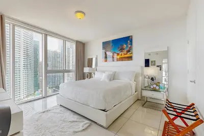 a white bedroom with a bed and large windows at Tony Ultimate Experience Miami in Miami