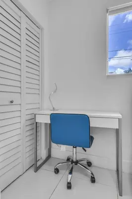 a blue chair sitting in front of a desk at Private Pool Home & Arcade game & Mini Basketball in Hollywood