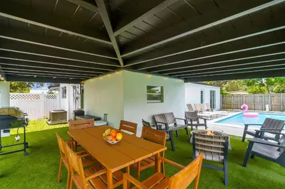 a patio with a table and chairs and a pool at Private Pool Home & Arcade game & Mini Basketball in Hollywood