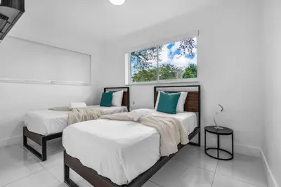 two beds in a room with a window at Private Pool Home & Arcade game & Mini Basketball in Hollywood