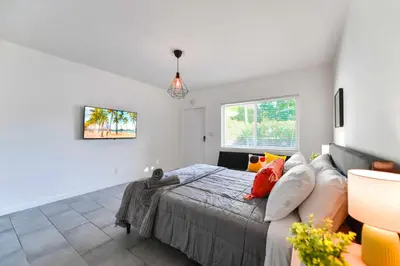 a bedroom with a bed and a couch at Charming Studio in a Beautiful Neighborhood Setting in Miami