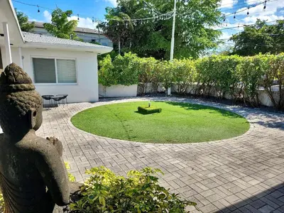 a garden with a small circle of grass in front of a house at Charming Studio in a Beautiful Neighborhood Setting in Miami