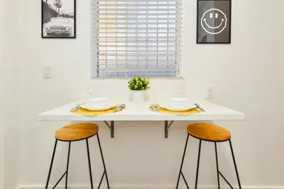 a white table with two stools in a kitchen at Charming Miami Studio in Prime Location in Miami