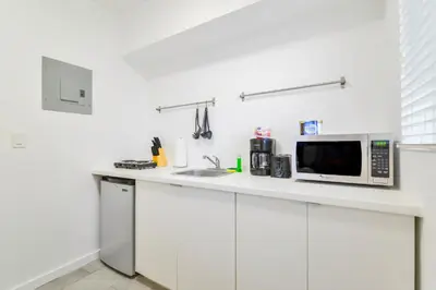 a kitchen counter with a microwave and a sink at Charming Miami Studio in Prime Location in Miami