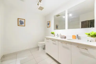 a white bathroom with a toilet and a sink at Stylish Midtown Miami Condo - Pool & Prime Location in Miami