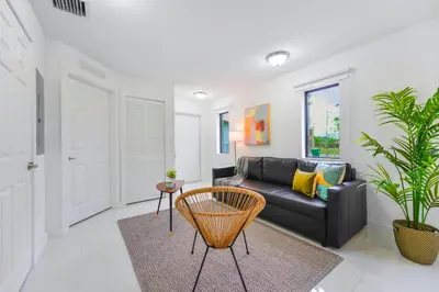 a living room with a black couch and a table at Prime Location Duplex for a Relaxing Stay in Miami