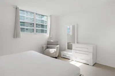 a white bedroom with a bed and a chair at Komffy Apartment with 2 King Beds OceanView at Tides in Hollywood