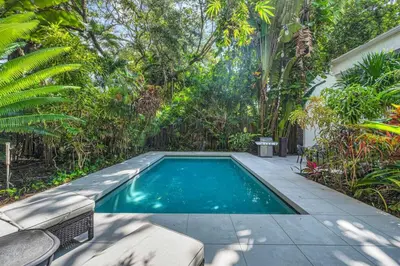 a swimming pool in the middle of a garden at Wonderful Tropical Pool House Miami Coconut Grove in Miami