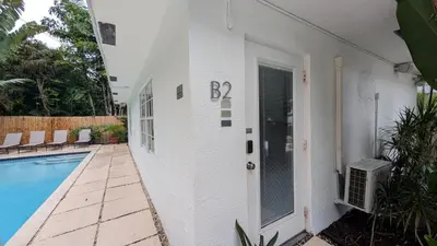 a house with a swimming pool next to a building at Inn On The Drive in Fort Lauderdale