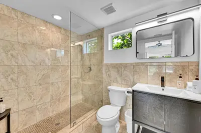 a bathroom with a shower and a toilet and a sink at Inn On The Drive in Fort Lauderdale