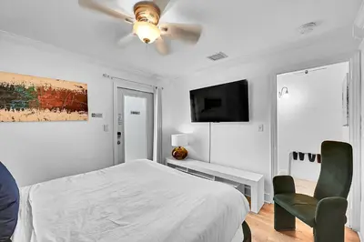 a white bedroom with a bed and a ceiling fan at Inn On The Drive in Fort Lauderdale