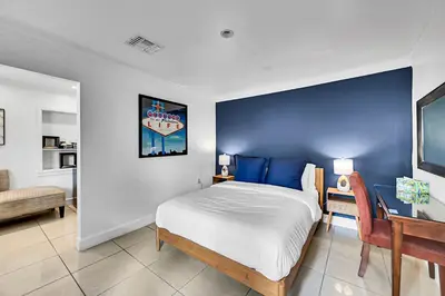 a bedroom with a bed with a blue wall at Inn On The Drive in Fort Lauderdale